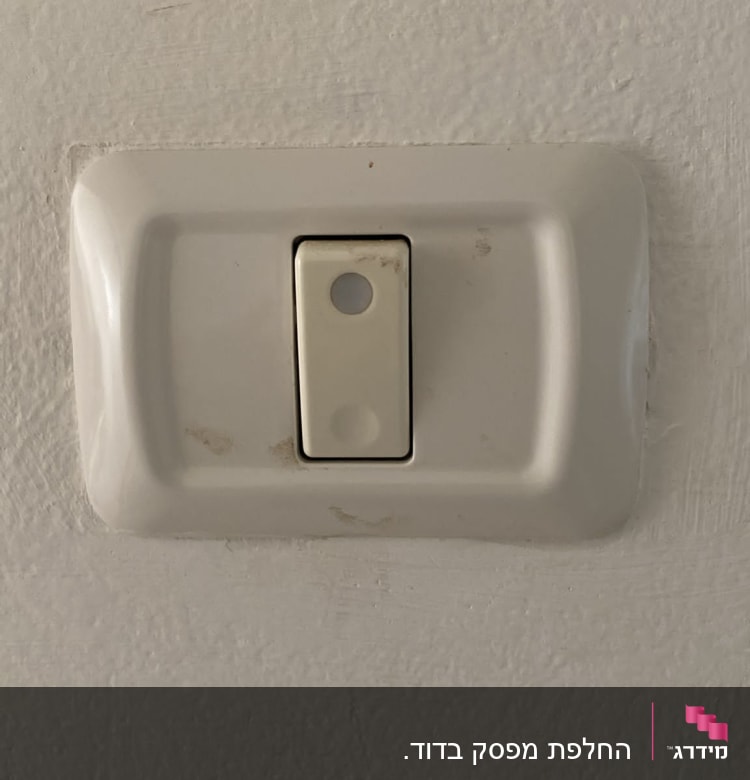 מתג חשמל לבן על קיר